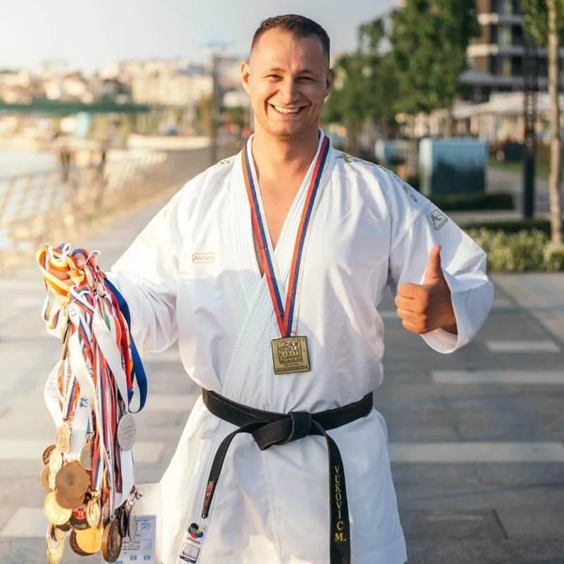 Milos Vukovic, PTD Fitness founder and world karate champion, with his competition medals